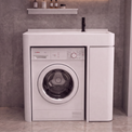 A white Bosch front-loading washing machine integrated into a matching white sideboard cabinet, set against a gray tiled wall with a small shelf holding bottles above.
