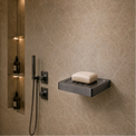 Modern bathroom shower area with soap dish and toiletries.