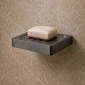 Modern bathroom shower area with soap dish and toiletries.