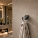 Towel hanging on a hook in a modern bathroom with neutral tones.