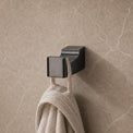 Towel hanging on a hook in a modern bathroom with neutral tones.