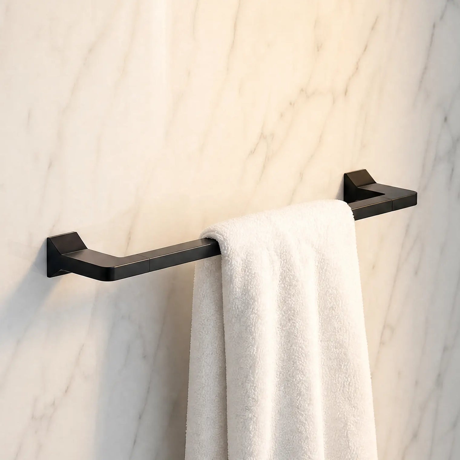 Black towel rack with a white towel against a marble wall.