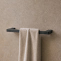 Towel hanging on a rack in a modern bathroom with neutral tones.