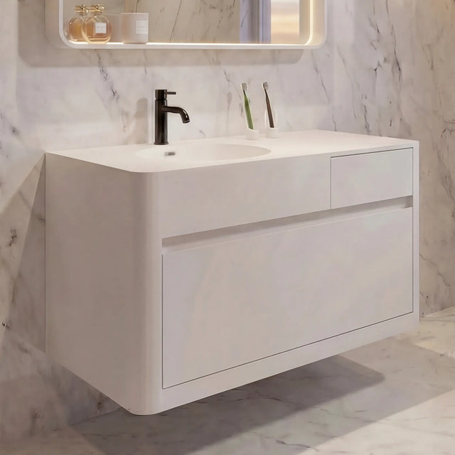 Modern bathroom with marble walls, a white vanity, and a large mirror.