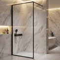Modern bathroom with marble walls, a shower enclosure, and a freestanding bathtub.
